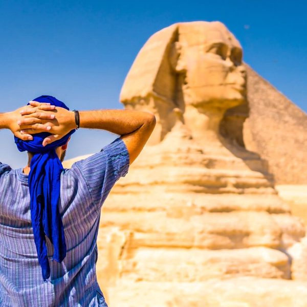 joven-turista-con turbante-azul-parado-cerca-de-gran-esfinge-giza-el-cairo-egipto